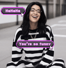 a woman wearing glasses and a black and white striped shirt is laughing with a you 're so funny popup