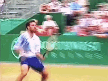 a man is playing tennis on a court in front of a sign that says ' coca cola ' on it