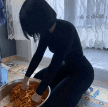 a woman is kneading something in a bowl