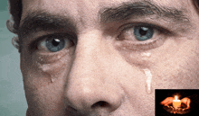 a close up of a man 's face with tears coming out of his eyes