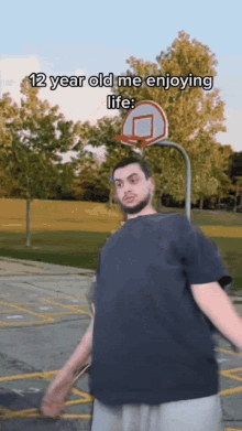 a man standing in front of a basketball hoop with the words 12 year old me enjoying life below him