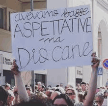 a group of people are holding up a sign that says `` avevamo fatte aspettative ma discane '' .