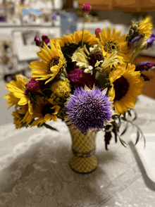 a vase filled with purple and yellow flowers