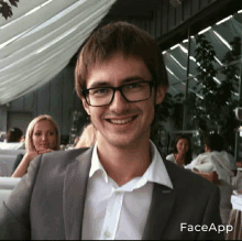 a man wearing glasses and a suit has faceapp written on the bottom of his face