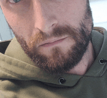 a close up of a man 's face with a beard