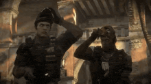 two soldiers are standing in front of a building and one of them has a t-shirt that says " army " on it