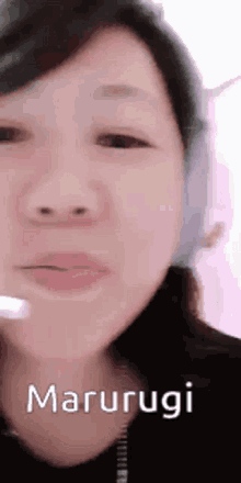 a close up of a woman 's face with the word marurugi written on it .