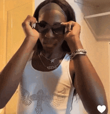 a woman wearing sunglasses and a necklace that says ' vote ' on it