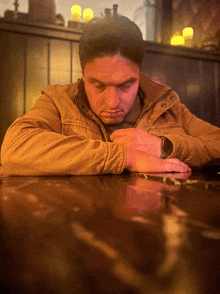 a man sitting at a table with his head down