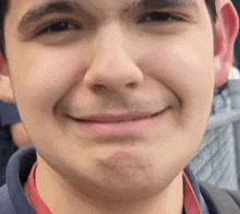 a close up of a young man 's face with a smile on it .