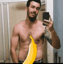 a shirtless man taking a picture of himself with a banana on his stomach