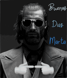 a black and white photo of a man wearing sunglasses and pointing at the word buenos dias marta