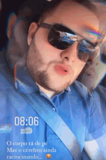 a man wearing sunglasses and a blue shirt has the time of 8:06