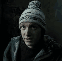 a man is wearing a knitted hat and a jacket .