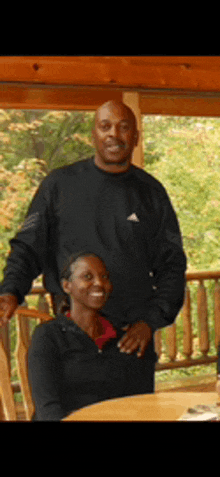 a man and woman posing for a picture on a porch