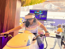 a woman wearing a virtual reality headset is riding a bike