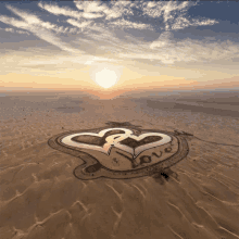 an aerial view of a heart in the sand with the word love written on it