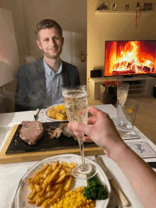 a man sits at a table with a plate of food and a glass of wine