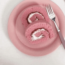 a pink plate topped with two slices of pink cake and a fork .