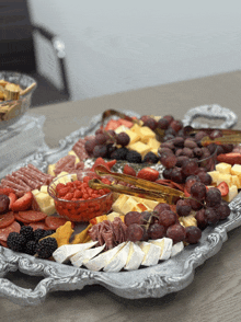 a silver tray filled with a variety of food including grapes