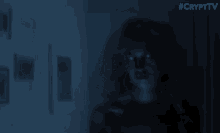 a ghostly figure is standing in a dark room with a blue background .