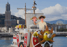 a man in a straw hat and sunglasses is standing on a ship in the water