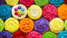 a bunch of colorful cupcakes with flowers on them