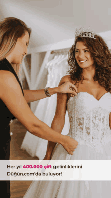 a woman in a wedding dress is helped by another woman