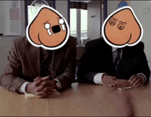 two men sitting at a table with cartoon faces on their heads