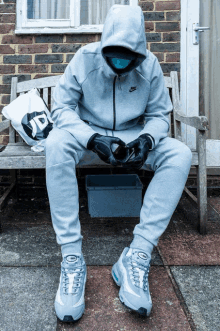 a man sitting on a bench with a jd bag behind him