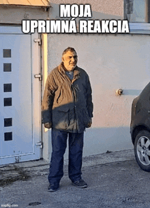 a man in a jacket is standing in front of a garage door with the words moja uporna reakcia written on the bottom