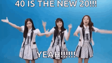 a group of girls are standing next to each other with their arms outstretched in front of a blue background .