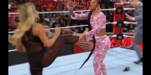 two women are wrestling in a wrestling ring and one is kicking the other 's leg .