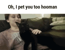 a woman sitting on a couch petting a black cat with the words oh i pet you too hooman above her