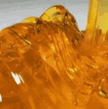 a close up of a yellow liquid coming out of a bottle .