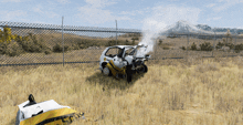 a yellow and white car is sitting in a field with smoke coming out of the engine