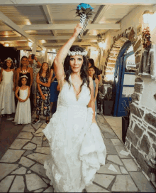 a woman in a wedding dress is throwing a bouquet of flowers