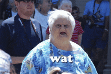 an older woman wearing a blue shirt with the word wat written on it