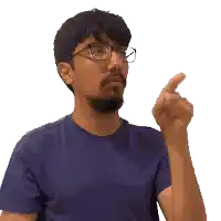 a man wearing glasses and a blue shirt is pointing his finger