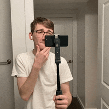 a man is taking a picture of himself with a phone on a tripod