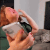 a woman is crying while holding a phone in her hand .