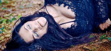 a woman is laying on the ground with her eyes closed .