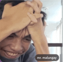 a man covering his face with his hands and the name mr. malungay is on the bottom right