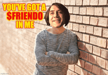 a man leaning against a brick wall with the words you 've got a $ friendo in me