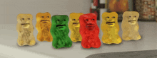 a row of gummy bears with faces are lined up on a counter