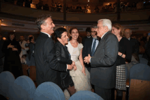 a man in a suit talks to a woman in a wedding dress