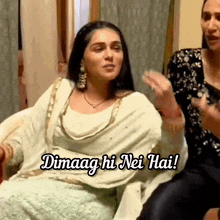 a woman in a white dress is sitting in a chair with the words dimaag hi nei hai .