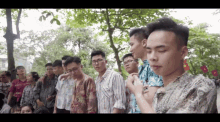 a group of young men standing in a line with one wearing a shirt that says ' abercrombie & fitch '