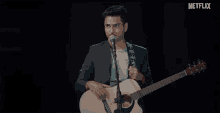 a man singing into a microphone while holding a guitar with netflix written on the bottom