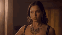 a woman wearing a necklace says as long as i get to kick someone 's ass !